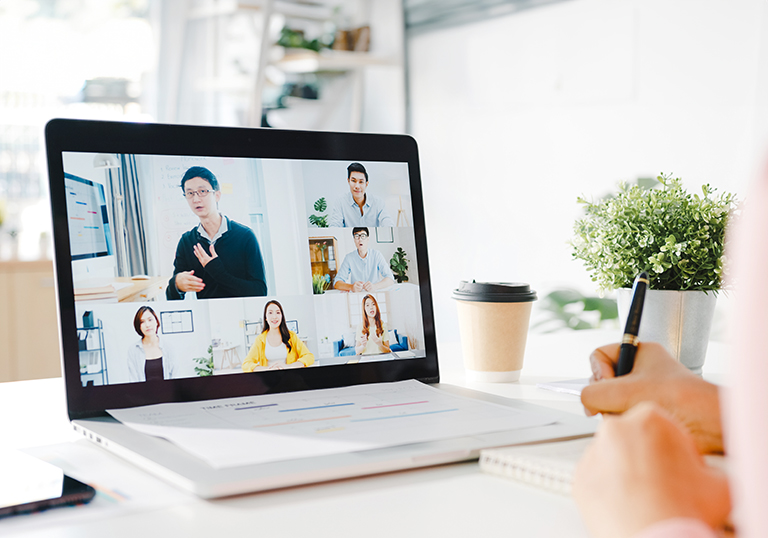 Young Asia businesswoman using laptop talk to colleague about plan in video call meeting while work from home at living room. Self-isolation, social distancing, quarantine for corona virus prevention.