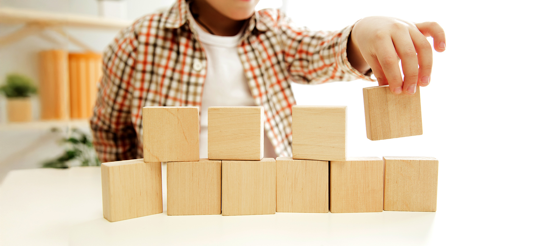 Little child sitting on the floor. Pretty boy palying with wooden cubes at home. Conceptual image with copy or negative space and mock-up for your text