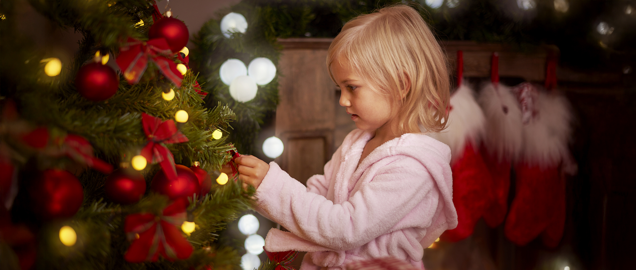 Little girl decorating a christmas tree